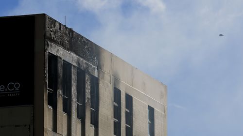 De la fumée s'échappe par les fenêtres alors qu'un drone surveille la scène après un incendie à Loafers Lodge le 16 mai 2023 à Wellington, en Nouvelle-Zélande. 