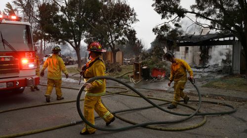 Santa Rosa firefighters carry hose as they battle hotspots in the Coffey Park area of Santa Rosa. (AP)