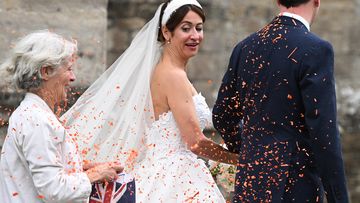 A woman throws orange confetti as former UK Chancellor George Osborne and Thea Rogers leave after their wedding at St Mary&#x27;s Church, in Bruton, England. 