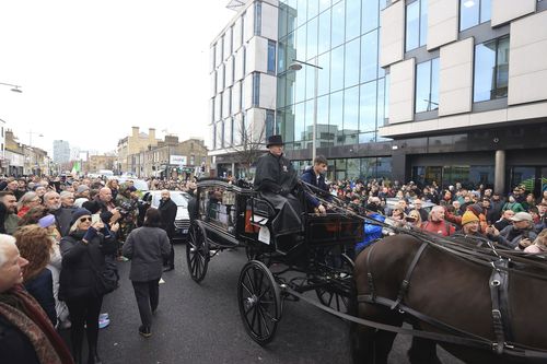 The funeral procession of Shane MacGowan makes its way through the streets of Dublin, ahead of his funeral in Co Tipperary, in Ireland, Friday, Dec. 8, 2023. 