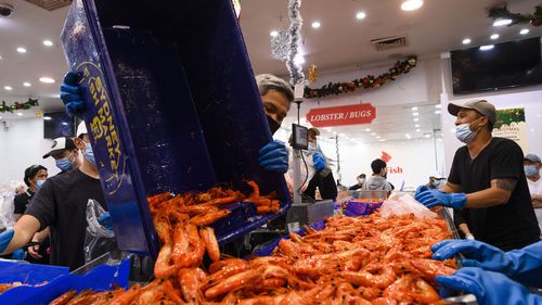 Workers in masks at Sydney Fish Markets on Christmas Eve. 