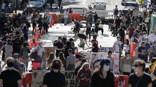 In this June 11, 2020, file photo artists paint large letters that read "Black Lives Matter" painted on a street near Cal Anderson Park inside what is being called the "Capitol Hill Autonomous Zone" in Seattle