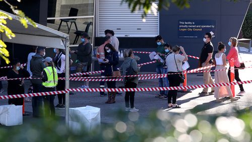 People line up outside a vaccination clinic at the Logan Entertainment centre in Brisbane.