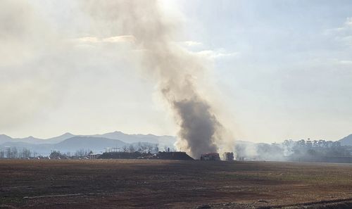 Smoke billows from the runway after the crash at Muan International Airport in South Korea.