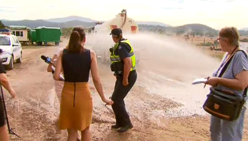 After giving the reporters a honk, the driver sprayed them. (9NEWS)