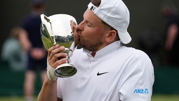 Dylan Alcott with his trophy after winning a second Wimbledon title.