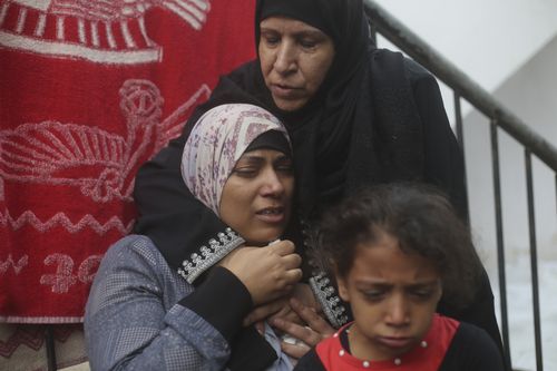 People help evacuate a Palestinian woman following Israeli airstrikes that targeted her neighbourhood in Gaza City.