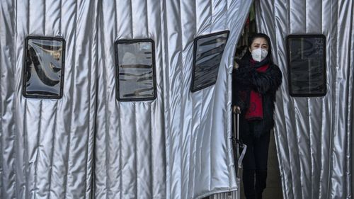 A Chinese woman wears a protective mask as she leaves a Beijing railway station on January 23, 2020 in Beijing, China. 