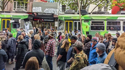 A largely maskless crowd marches through Melbourne's CBD.