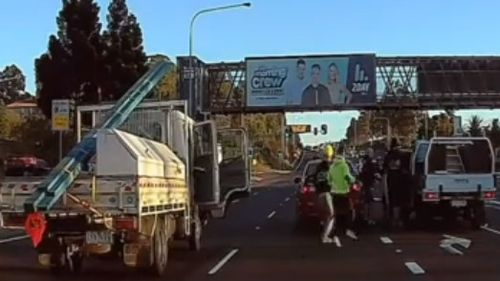 The occupants of a third vehicle race across traffic to intervene.