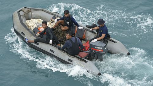 Indonesian navy divers arrive on boats after conducting operations to lift the tail of AirAsia Flight 8501. (AAP)