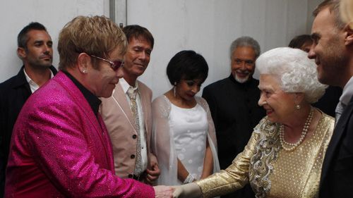 Queen Elizabeth II meets Sir Elton John backstage at The Diamond Jubilee Concert outside Buckingham Palace, London in 2012. (AAP)