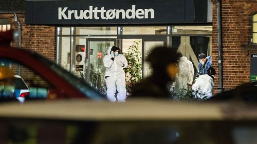 Forensic experts investigate the scene in front of the cafe Krudttoenden. (AAP)