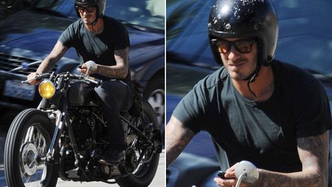 Text addict: David Beckham uses his phone while riding motorbike