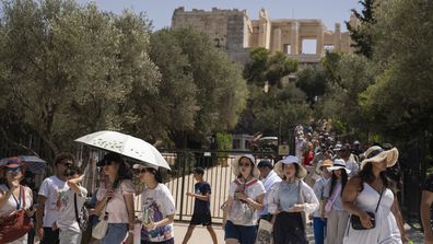 Tourists exit the ancient Acropolis of Athens as the Greek culture ministry shut down the monument most of the day because of heat, Friday, July 14, 2023.