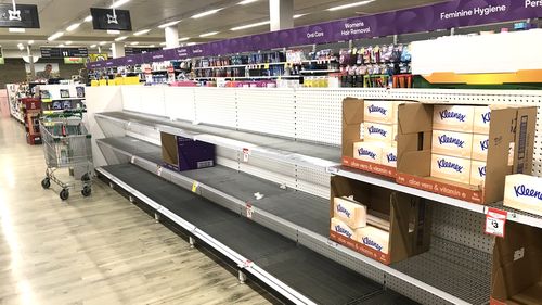 Bare toilet paper and tissue shelves in Sydney supermarket.