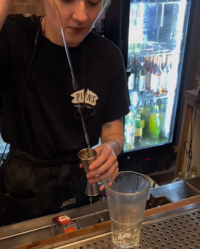 bartender using measuring device for nip