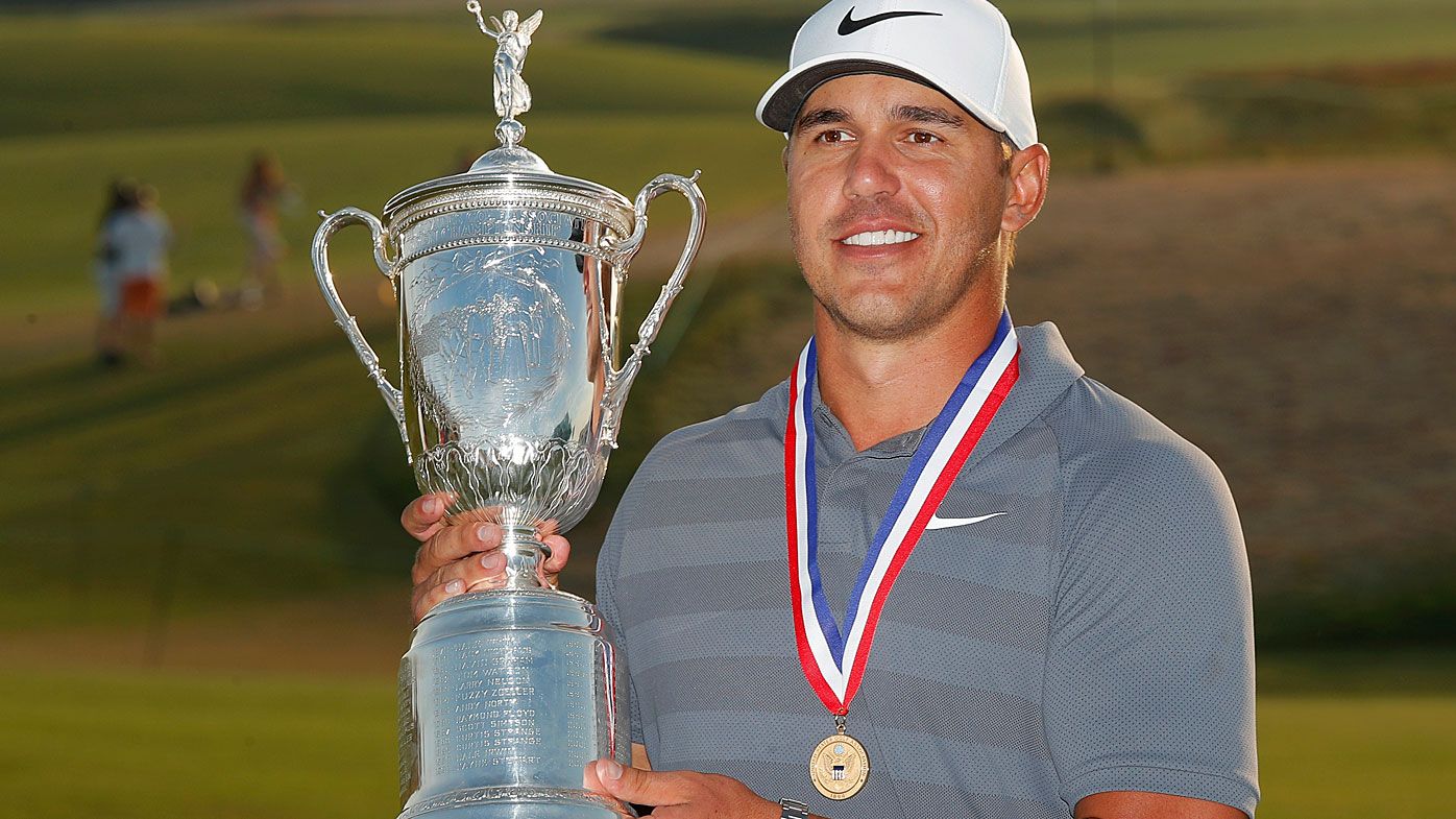 Brooks Koepka holds up the Golf Champion Trophy after winning the U.S. Open in 2018