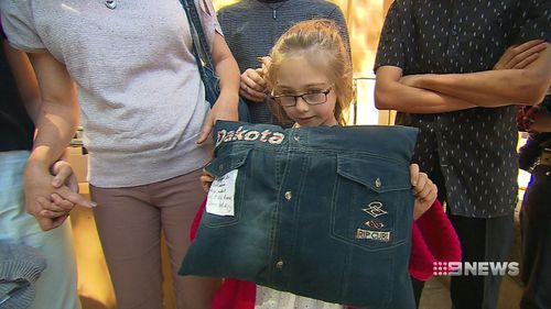Dakota Lawlor held a pillow made of her father’s clothing today as joined her mother, Michelle, and siblings at the Adelaide Magistrates court. (9NEWS)