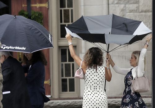 Rain didn't stop more than 80 mourners standing outside the church, unable to fit inside the 1200 seat chapel. (AAP)