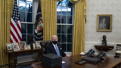 President Joe Biden signs a series of executive orders in the Oval Office of the White House, Wednesday, Jan. 20, 2021, in Washington.