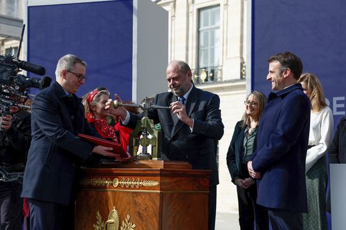 French President Emmanuel Macron, right, and Justice Minister Eric Dupond-Moretti, centre, attend a ceremony to seal the right to abortion in the French constitution, on International Women's Day, at the Place Vendome, in Paris, France March 8, 2024. 