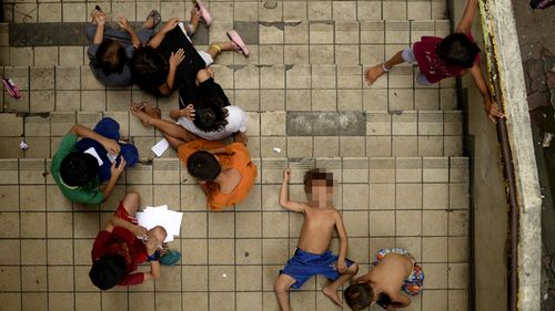 Homeless children play on a staircase at the Light Railway Train Carriedo station in Manila. Photo: AFP