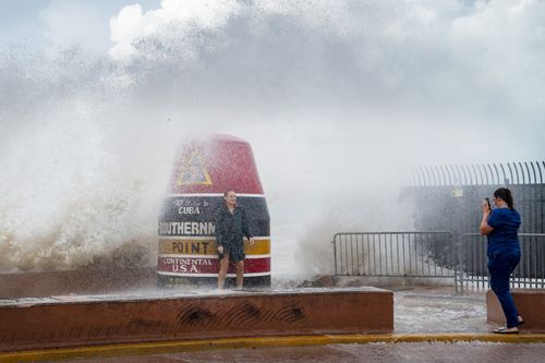 Visitors to the Southernmost Point buoy brave the waves made stronger from Hurricane Idalia on Tuesday, Aug. 29, 2023, in Key West, Fla.  