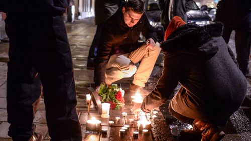 Mourners light candles outside the French embassy in Stockholm in Sweden to support victims of the Charlie Hebdo attack. (AAP)