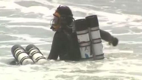 Divers search for the body of woman who died trying to save a boy from a rip on the New South Wales north coast. (9NEWS)