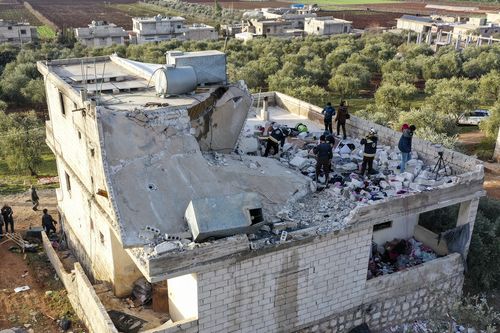 People inspect a destroyed house following an operation by the U.S. military in the Syrian village of Atmeh, in Idlib province, Syria, Thursday, Feb. 3, 2022. 