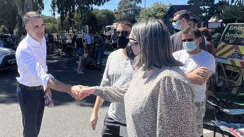Opposition Leader Peter Malinauskas shakes hands at a polling station.