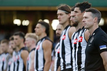 Collingwood coach Craig McRae stands with his team for the national anthem