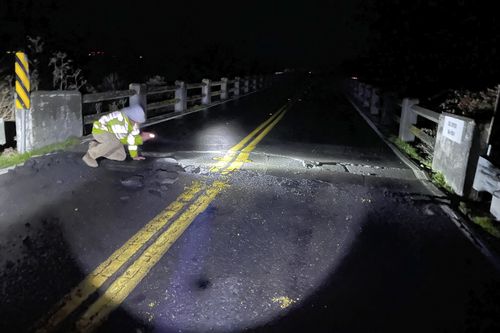 Sur cette photo fournie par Caltrans, l'un de leurs ouvriers inspecte Fernbridge, un pont en arc en béton de 402,3 m qui enjambe la rivière Eel, à la suite d'un tremblement de terre près de Fortuna, en Californie, le mardi 20 décembre 2022.