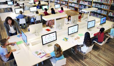 Kids in a library on computers. 