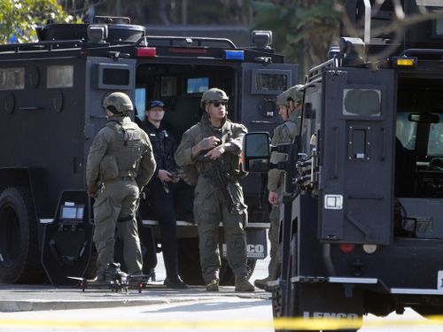 SWAT personnel surround a van, in Torrance Calif., Sunday, Jan. 22, 2023. A mass shooting took place at a dance club following a Lunar New Year celebration, setting off a manhunt for the suspect.