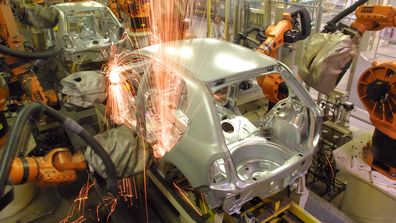 Sparks fly as robots converge to weld joints on a Skoda car body at the Skoda plant 