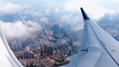 Airplane window view at the skyscrapers of Hong Kong