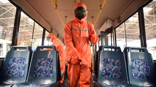 Health workers in Pyongyang disinfect a bus, as part of preventative measures against Covid-19.