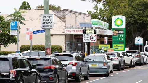 Carros fazendo fila em frente a um posto de gasolina em Mascot, Sydney.