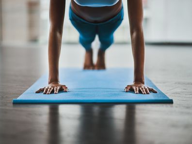 Shot of a woman doing pushups during her workout routine at home.