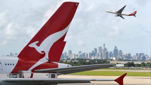 "SYDNEY, AUSTRALIA - 14 MARZO 2012: Aerei Qantas e pinna caudale con vista in lontananza del centro di Sydney - Aeroporto di Sydney"