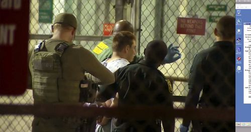 Nikolas Cruz is taken into custody by police after the massacre last night. Picture: AAP