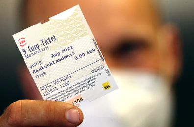 20 May 2022, Berlin: A man holds a 9-euro monthly ticket in the Potsdamer Platz subway station. On Friday, the Bundesrat approved the financing law passed by the Bundestag for the special campaign, which is to start on June 1 for three months. Photo: Wolfgang Kumm/dpa (Photo by Wolfgang Kumm/picture alliance via Getty Images)