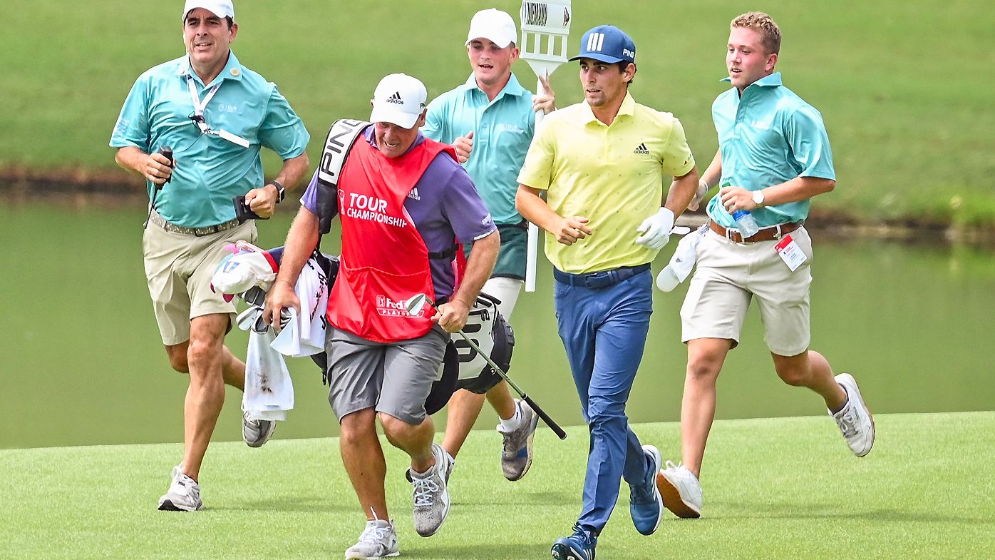 Joaquin Niemann of Chile runs with his caddie Gary Matthews on the 18th hole, breaking the record