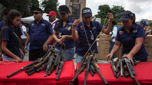 Seized weapons on display in Caracas, Venezuela. (AAP)