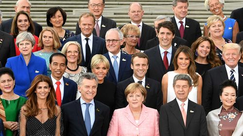 G20 leaders and their spouses gather for a group photo.