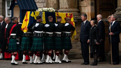 Edinburgh, Scoția - 11 SEPTEMBRIE: Viceamiralul Timothy Lawrence și Prințesa Ana a Marii Britanii, Prințesa Regală stau solemn în timp ce sicriul Reginei Elisabeta a II-a, acoperit cu standardul regal scoțian, își încheie călătoria de la Balmoral la Palatul Holyroodhouse pe 11 septembrie 2022 în Edinburgh, Statele Unite ale Americii. Regatul.  Elizabeth Alexandra Mary Windsor s-a născut în Broughton Street, Mayfair, Londra la 21 aprilie 1926. S-a căsătorit cu Prințul Philip în 1947 și a preluat tronul Regatului Unit. 