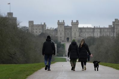 People walk their dogs on the Long Walk at Windsor, England, on Christmas Day, Saturday, Dec. 25, 2021. 