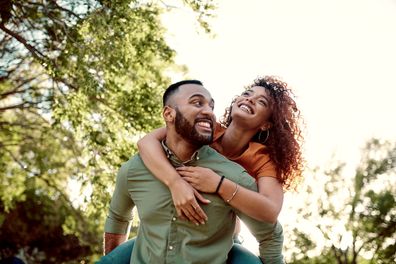 Couple dating. Young man and woman together. Happy couple. Man giving woman piggyback. Boyfriend and girlfriend.